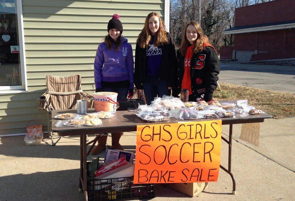 Sara Ruyle, Casey Fellin, and Rachel Boeck work the bake sale fundraiser Saturday morning for the Girls' Soccer team. Other players stood on the street corners collecting change for the parent funded sport. 