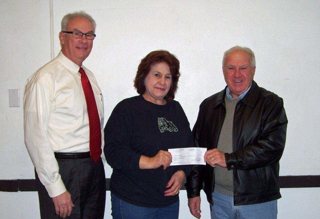 Accompanied by Kyle Hlafka, Superintendent of Staunton Unit School District 6, Mike Hailstone, Chairman of the Gillespie Knights of Columbus Tootsie Roll Drive presents a check in the amount of $1,757.24 to Special Education staff member Marian Mayfield.