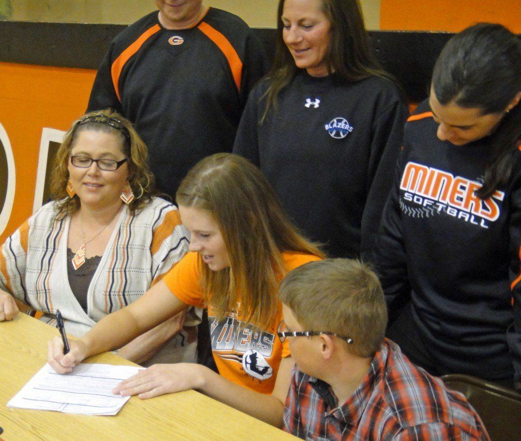Taylor Monke signing her letter of intent with step-mother Renee Monke, brother Austin Monke, coach Michelle Smith, LCCC coach Ronda Roberts, and father Jeff Monke.