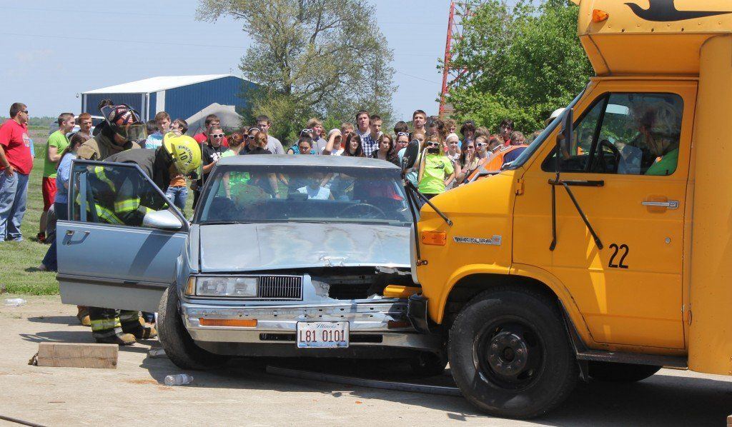 Students look on as fire department volunteers rescue victims.