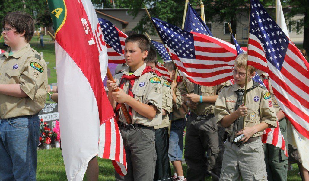 Boy Scout Troop 51 stand beside VFW Post 4547 of Gillespie, IL holding American flags. 