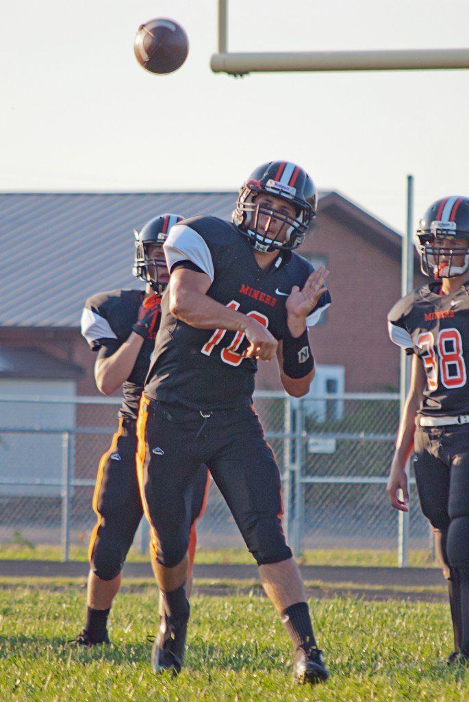 Logan Cooper shotguns a pass to his teammate in the high school football scrimmage to kick off the football season.