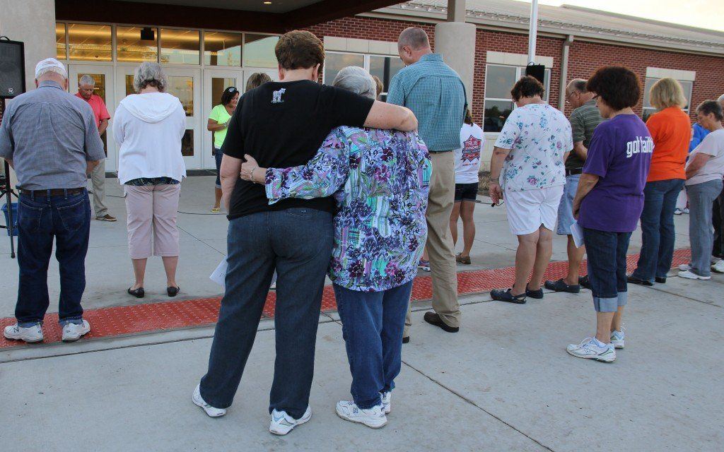 Members of the First Christian Church in Gillespie hold each other as they pray individually. The Moms in Prayer group was to thank of the prayer walk. Read more about the event. 
