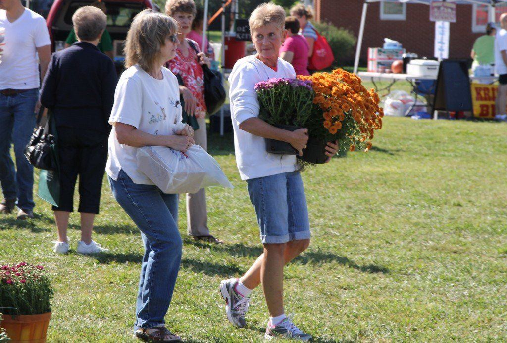 Customers walked around with mums they purchased from the Illinois Valley Rehabilitation Center during the Fall Festival Saturday morning.