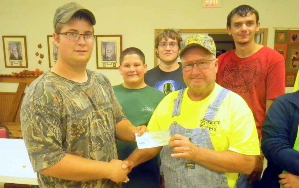  4-H Top Shots Treasurer, Kyle Reid receives a check from Dennis Baker of Quail Forever Illinois Pioneer Chapter in support of the 4-H Shooting Sports program.
