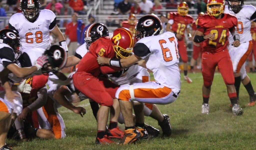 Hunter Vesper takes down his opponent in the back field Friday evening in the Miners match-up with Roxana. The Miners beat Roxana 18-17 to extend their winning streak to 7-0.