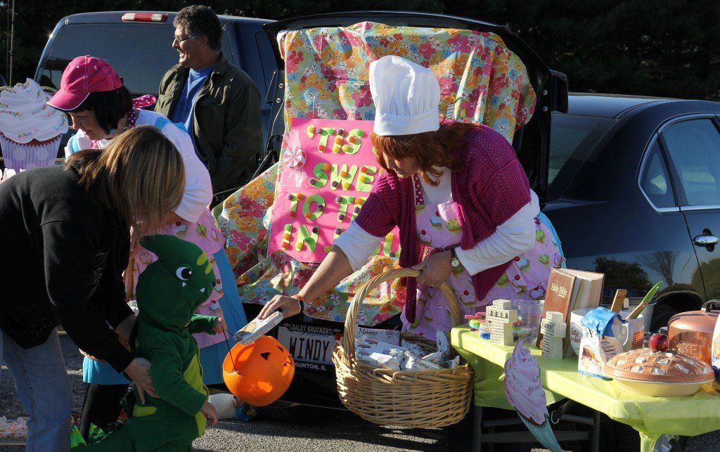 Donna Easton and Brenda Lowe hand out treats as they act as bakers with their "Tis' so sweet to trust in Jesus" themed trunk.