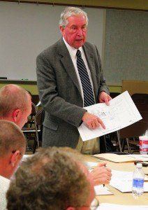 Tom Hyde presents the board with bid information for the baseball field tiling, stage curtains, and the gym sound system.