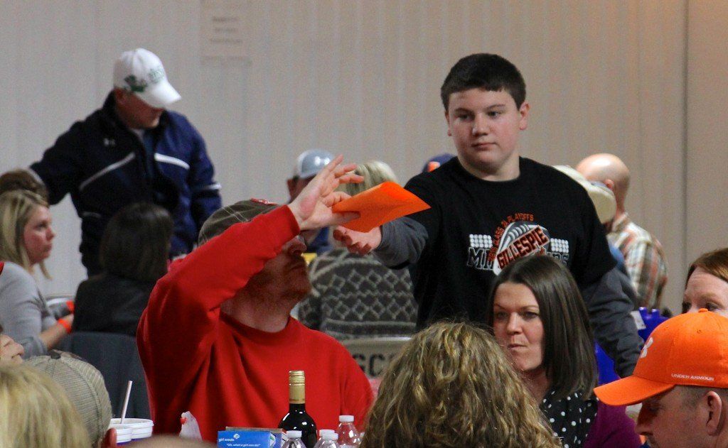 Stephen DeMartini volunteers his time to help out at the annual trivia night held by the Partnership. DeMartini collects the answer sheet from Mike Bellovich. 