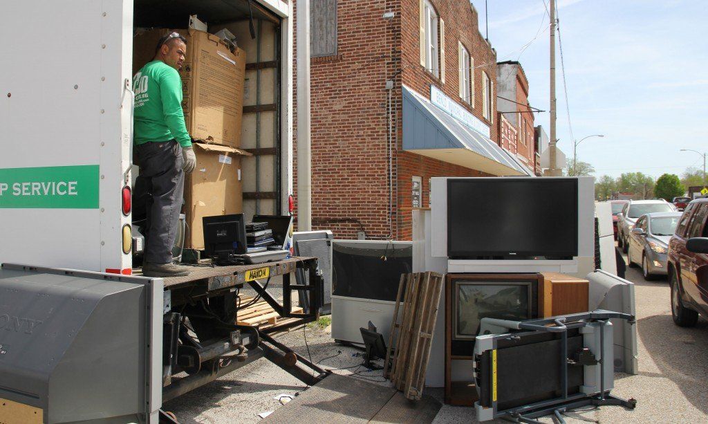 Televisions rest along the truck and curb as the 18' truck is filled to capacity. 