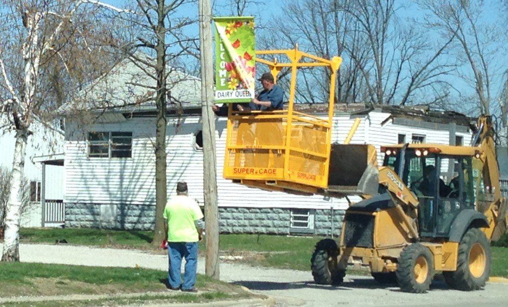 City of Gillespie workers replace the pole banners with bright colored spring ones. 