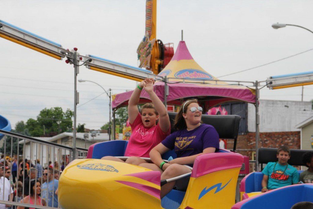 Girls riding the tilt-a-whirl ride have a blast as they are swung around in a swift motion. 