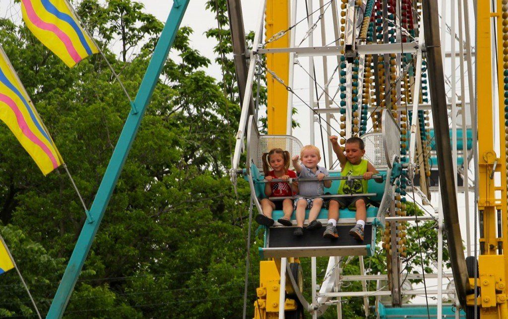 Kids waive to their parents as they come around on the ferris wheel. 