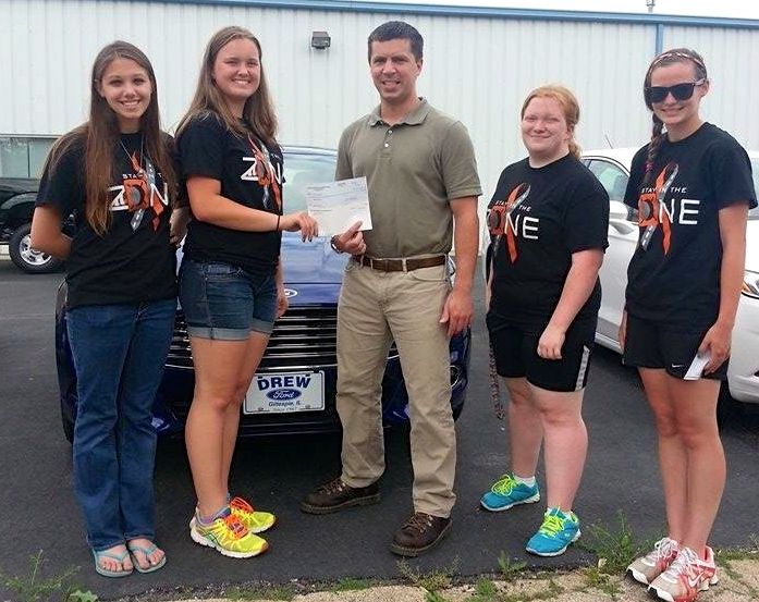 Jeff Drew of Drew Ford in Gillespie presents MPACT'D with the funds raised from the Drive One for Ur School event held at Ageless early this year. 