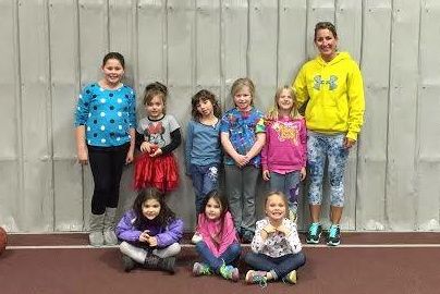 The local girl scout troop poses with Regie Byots, manager and personal trainer of Ageless, after touring the gym and learning the fundamentals of exercise. The troop qualified to earn a badge after they completed it. 