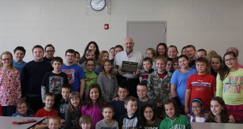 Morrie Giaudrone poses with elementary students last Friday morning after being honored with a plaque from the school district. The plaque thanked Giaudrone for his contribution of the Bengal tiger, which is mounted in the Common's Area in the Ben-Gil Elementary School. 