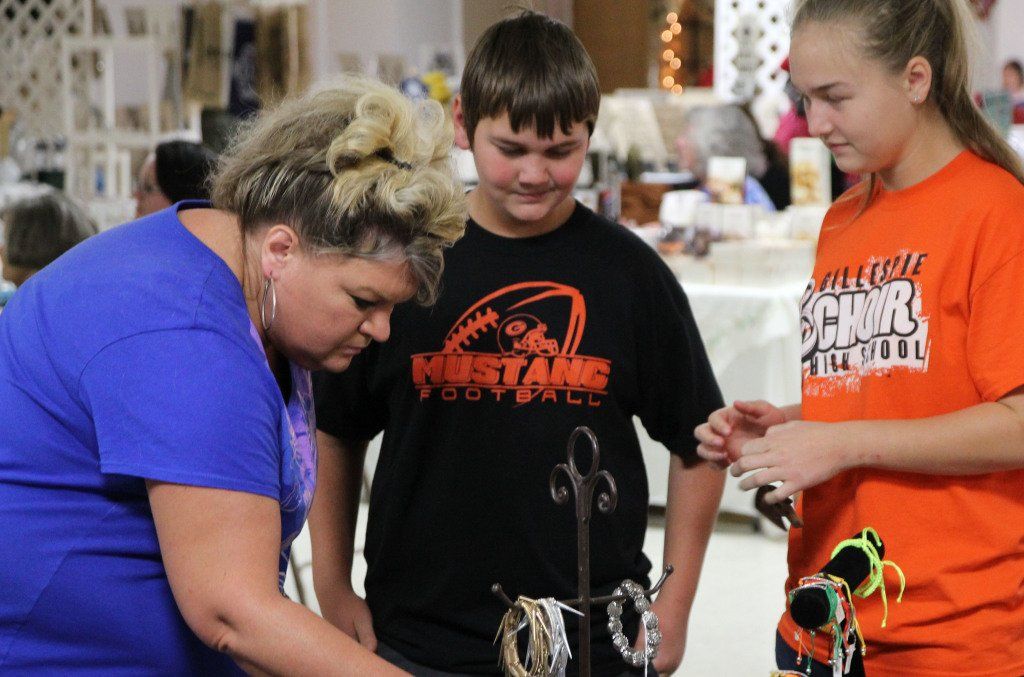 Dawn Farris, left, along with her children browse the selection yesterday at HEIDI's first annual Holiday Market.