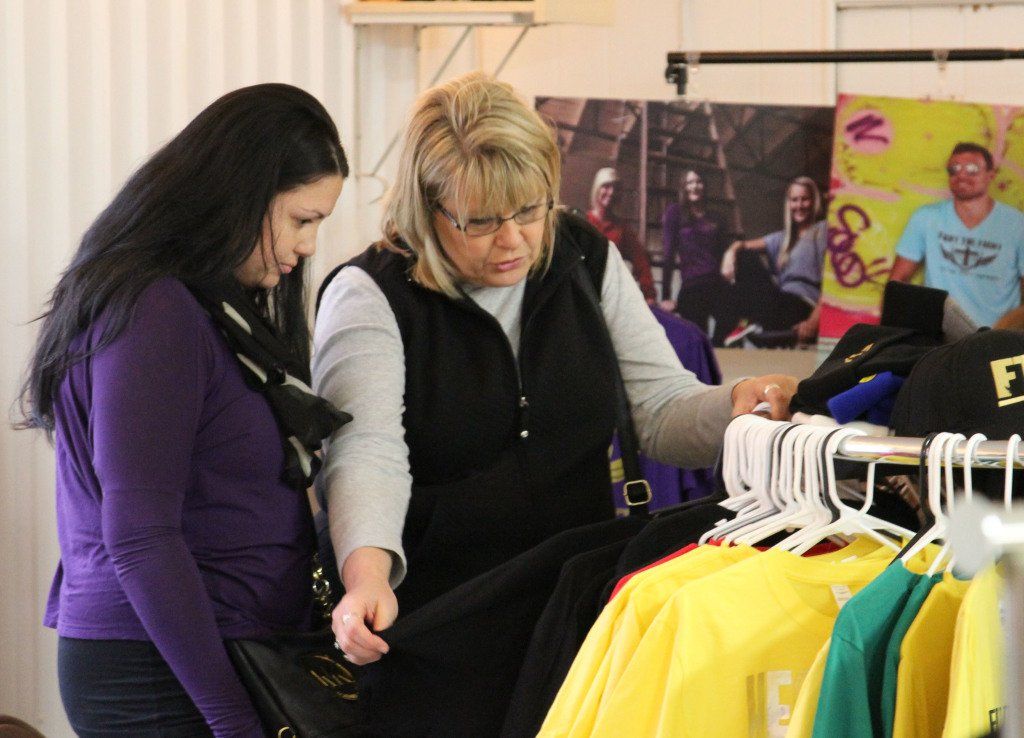 Kelly Vesper, right, and daughter, Veronica Vesper, check out shirts sold by Fight the Fight yesterday at HEIDI's Holiday Market. The market attracted hundreds of people. 