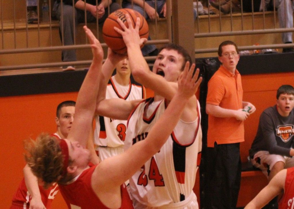 Evan Price goes over his opponent to score a basket.
