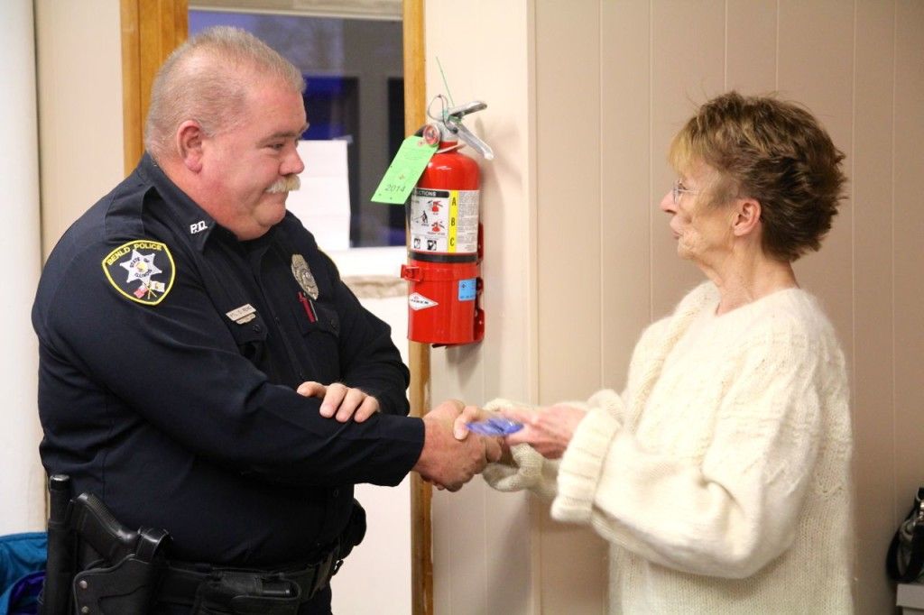 Mayor Gloria Sidar, right, presents Officer Reno, left, with his corporal pins