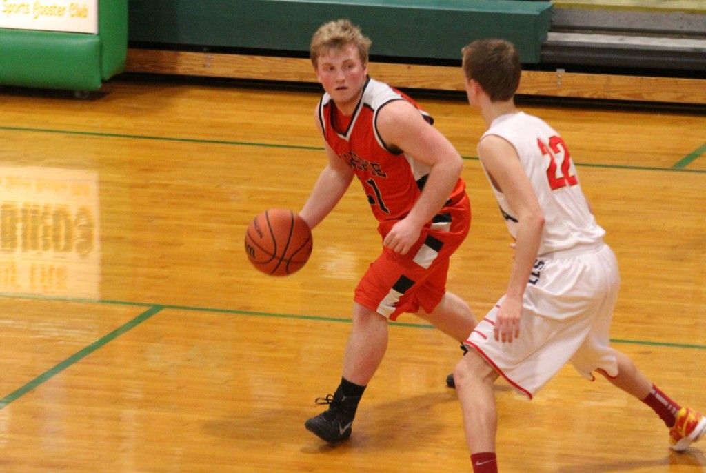 Eli Fox passes around his defender Thursday evening in the semifinal regional game. The Miners lost to Roxana 47-57 to end their season. 