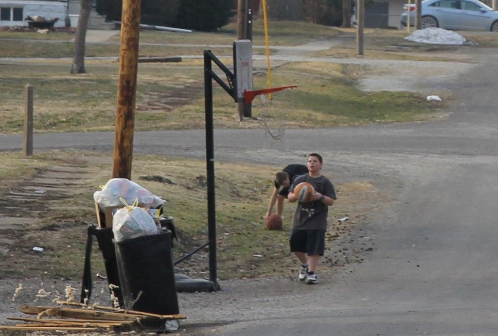 Beautiful weather attracted many youngsters outdoors last week. Pictured, two boys shoot baskets outside on Thursday. 