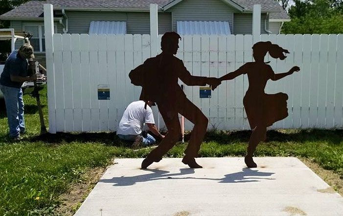 Volunteers for Build Benld install a white fence behind the dances located near the entrance in Benld by TJ's. 