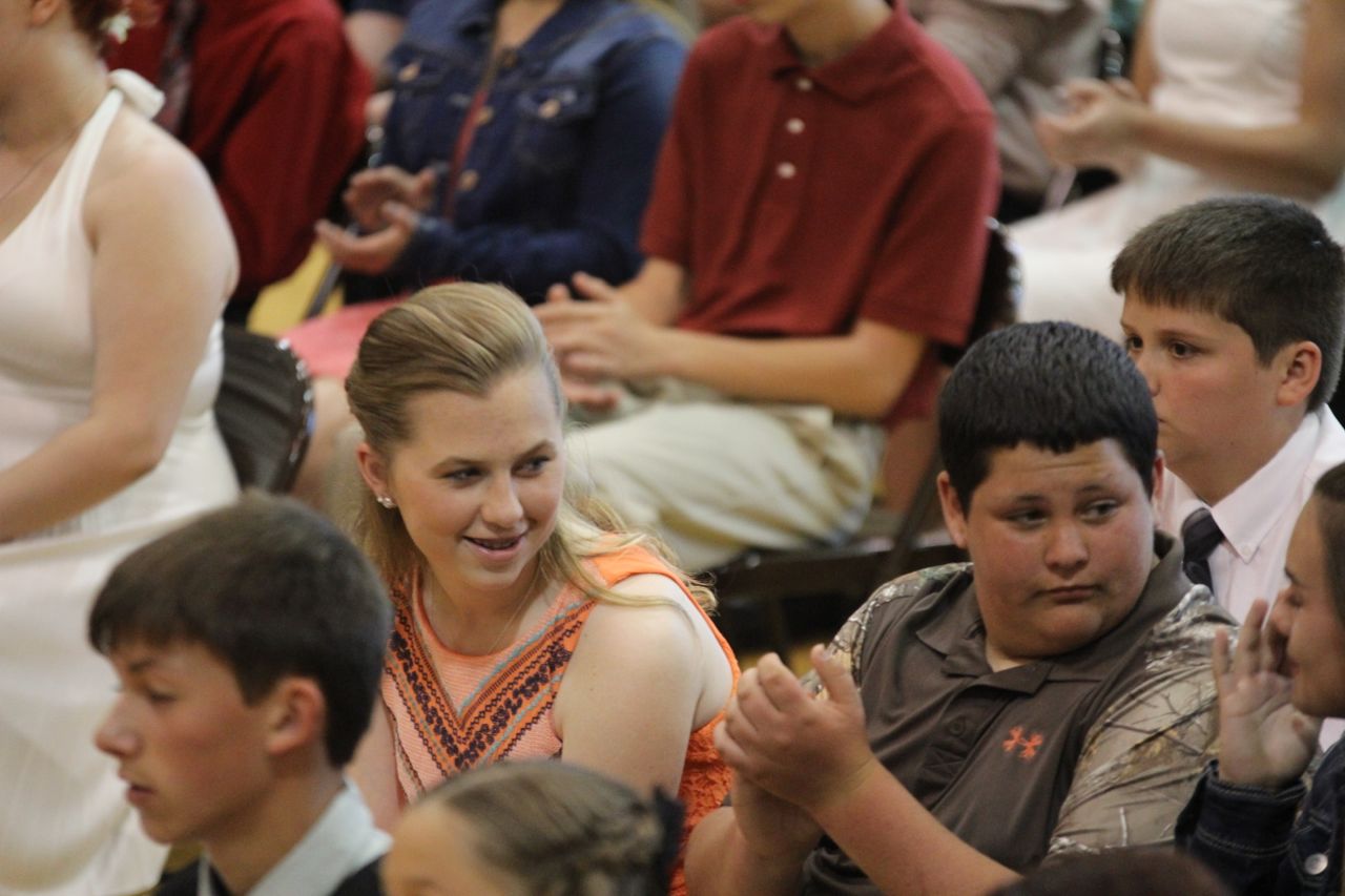 Lexie Bussmann (left) and Jerod Brown (right) have a side conversation with a classmate during the ceremony. 