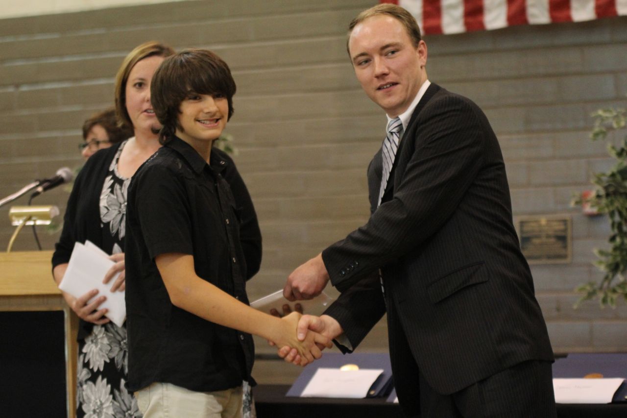 Austin Cole accepts his 8th grade diploma from school board member Peyton Bernot. 