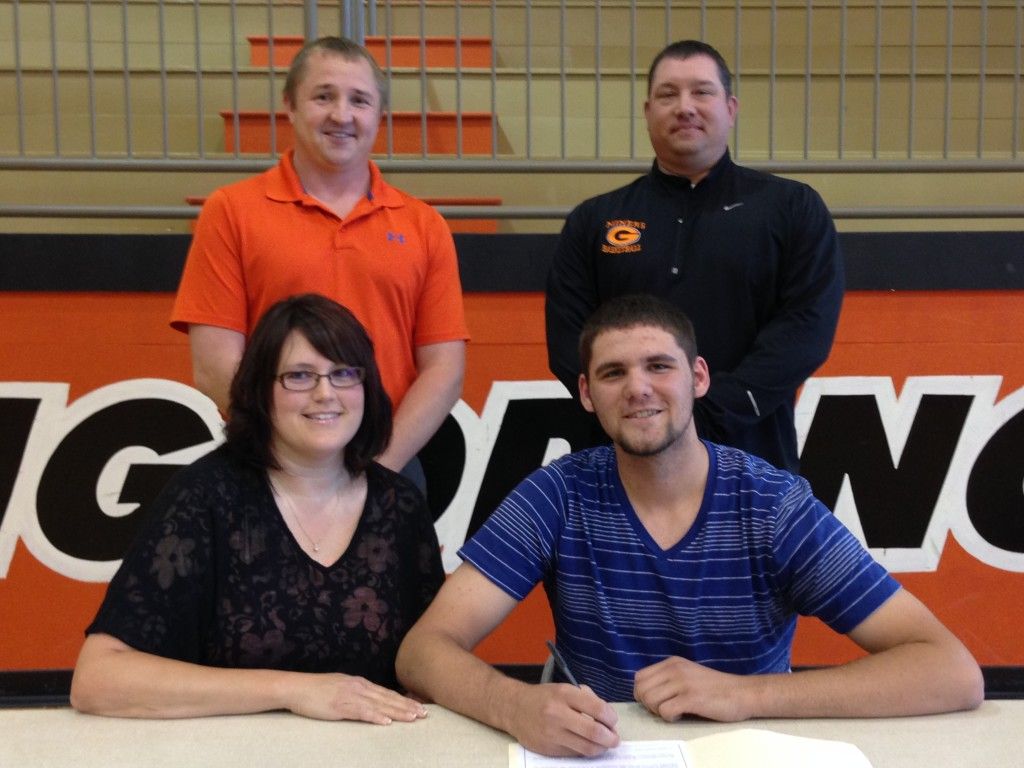 Quentin Zenner (seated right) signing with mother Nikki Zenner to the left. Standing behind is assistant coach Matt Brawner and head coach Casey Sholtis. 