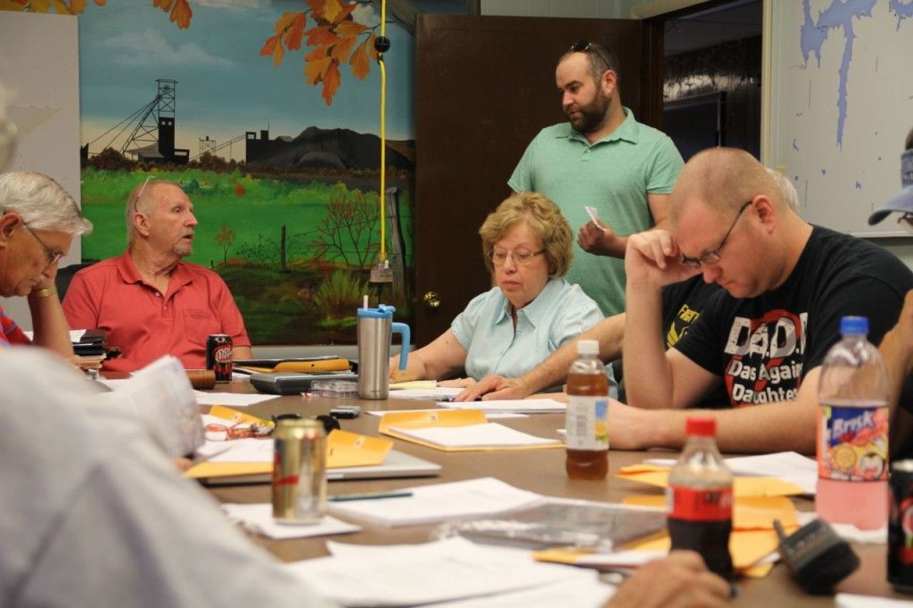 Clinton Sanders (green shirt) pleads his case with Mayor John Hicks (red shirt, left).