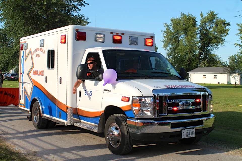 Chris Releford, an EMT with the Gillespie-Benld Area Ambulance Service, tosses out candy during the Dorchester parade. (Photo by the Village of Dorchester)