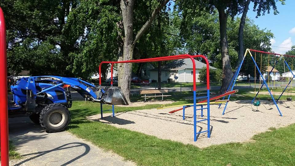 Village officials in the Village of Wilsonville and volunteers team up to paint the playground equipment in the park last week.  (Photo by the Village of Wilsonville)