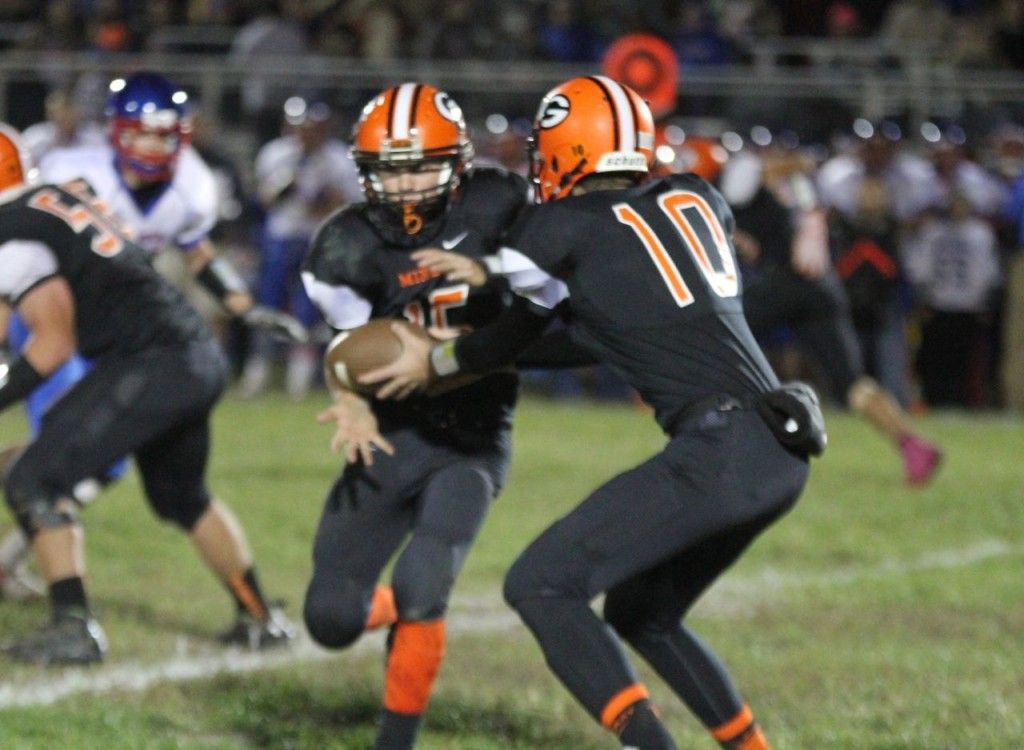 Quarterback Daniel Dobrino hands the ball off to Tate Wargo.