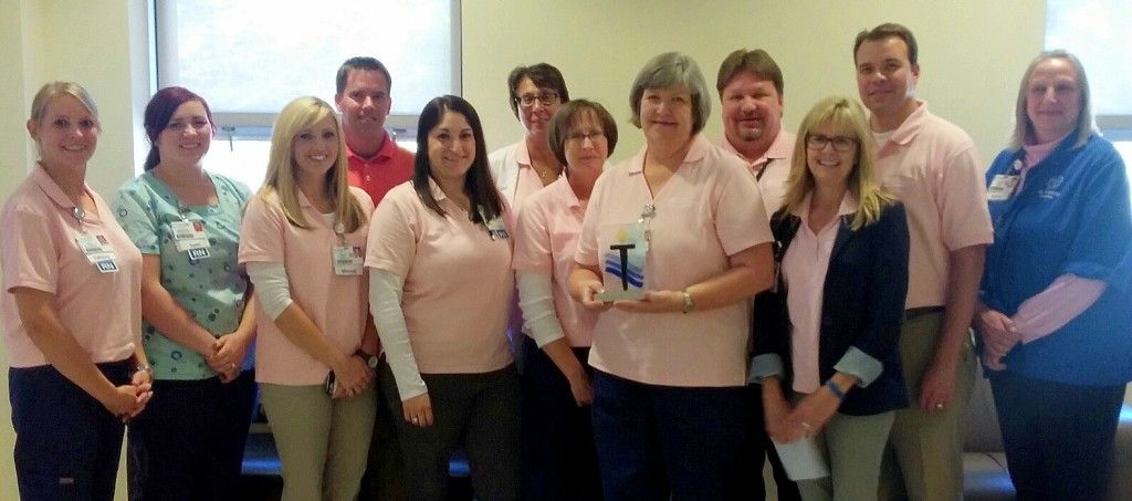 Jan Thomack (fifth from left with plaque) honored with the first HSHS St. Francis Hospital Torch Award.