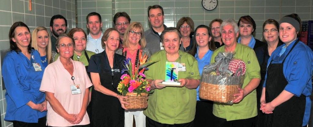 Beth Coleman shown receiving her award and prizes with many FANS colleagues and other hospital department leaders.