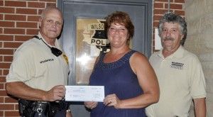 Wilsonville Police Chief Wayne Watkins presents a check for $1,500 to Wilsonville Village President Annetta Veres Tuesday night as ordinance officer Bob Reimann looks on. Watkins obtained the grant from Walmart to be used for police department upgrades. Watkins said the money will help with the purchase of new winter uniforms, acquisition of radio equipment and the purchase of computer programs.