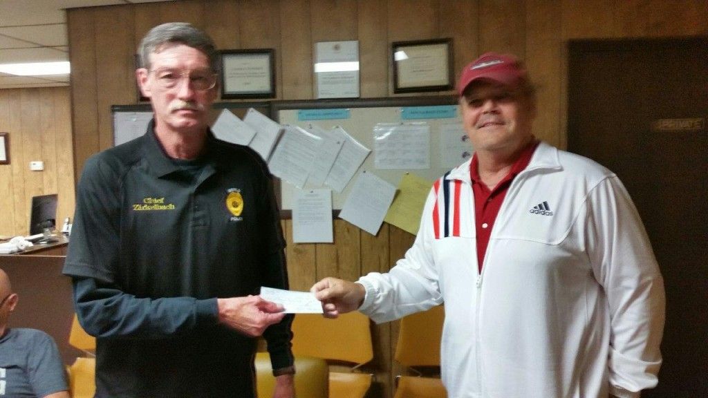 Benld Police Chief Jim Zirkelbach accepts the donation fromBuild Benld member Tom Allan.